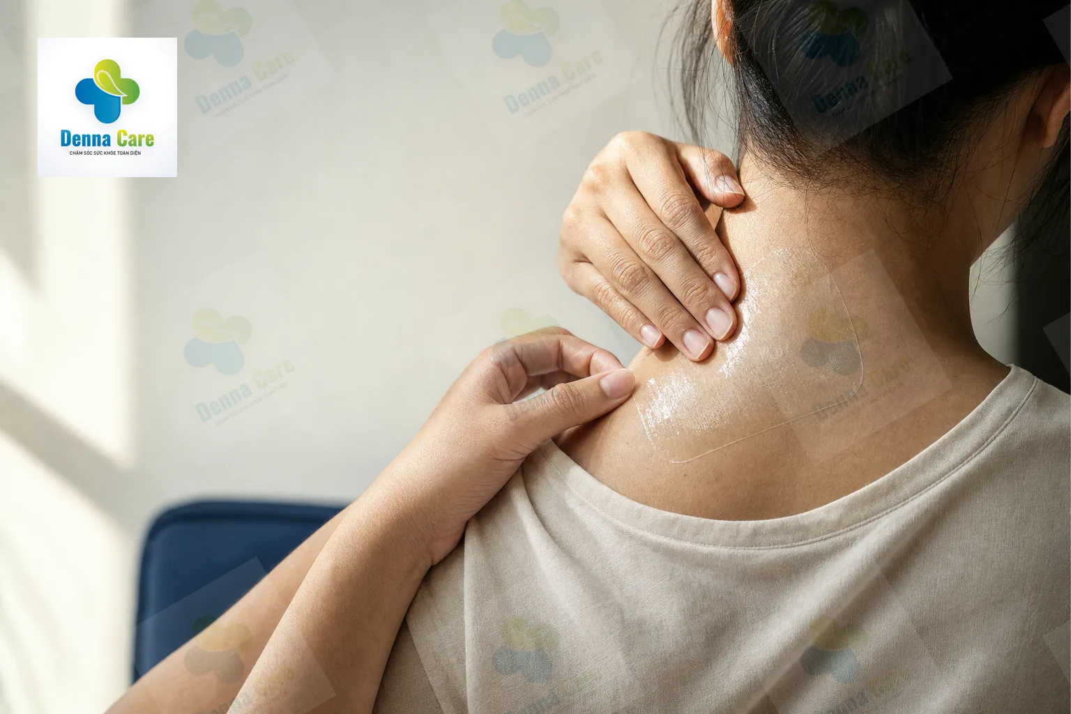 Đôi tay đang dán miếng dán hỗ trợ giảm đau lên vùng cổ vai gáy