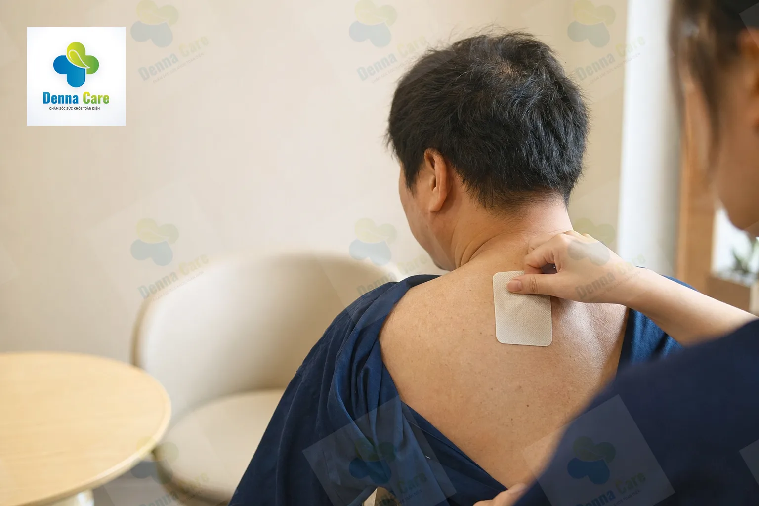 Người đang được dán miếng dán giảm đau vùng vai gáy trong tư thế ngồi